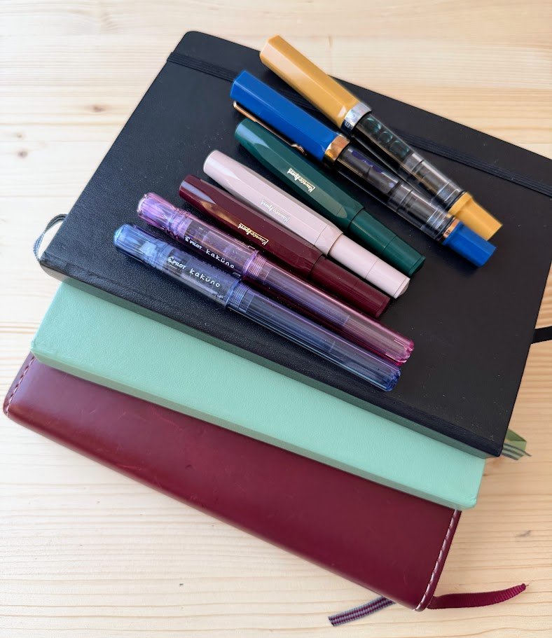 stack of journals and fountain pens